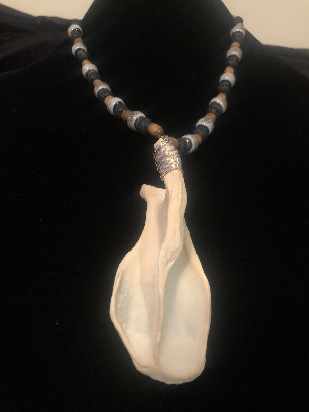 Beaver shoulder bone necklace with blue, brown, wood, and black volcanic beads