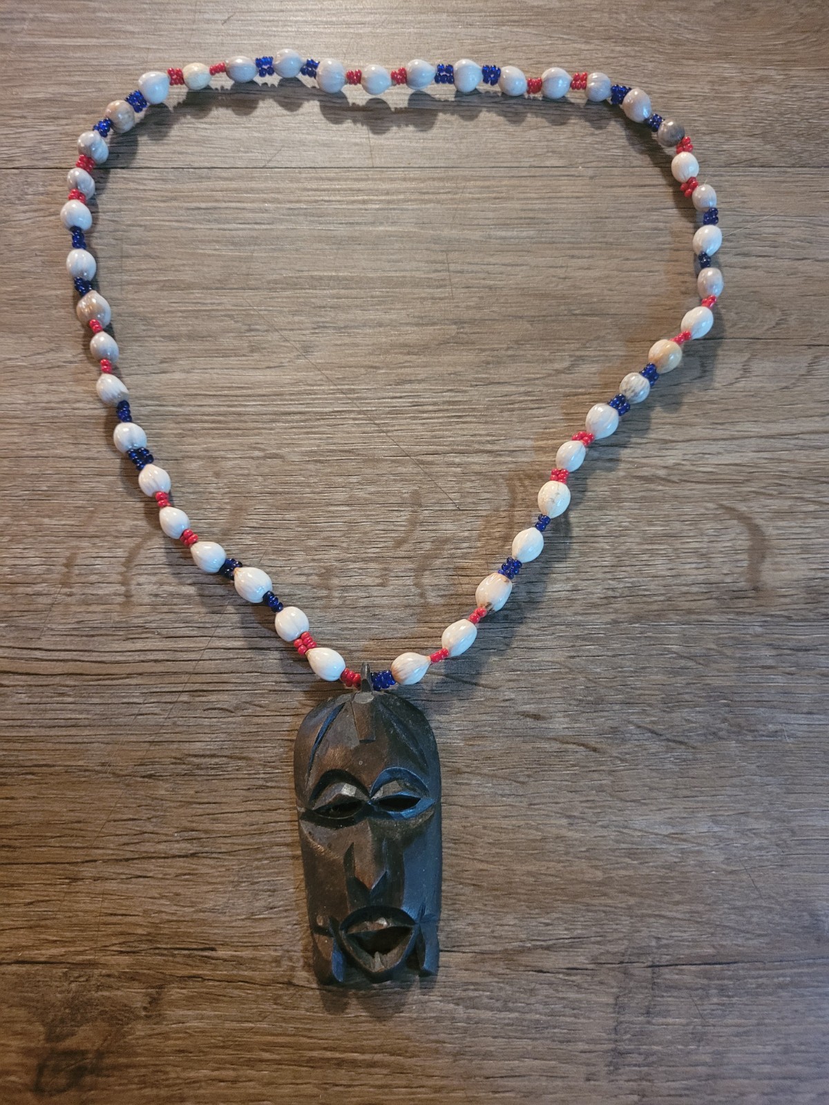 handmade necklace carved wooden face pendant and white, blue, and red beads