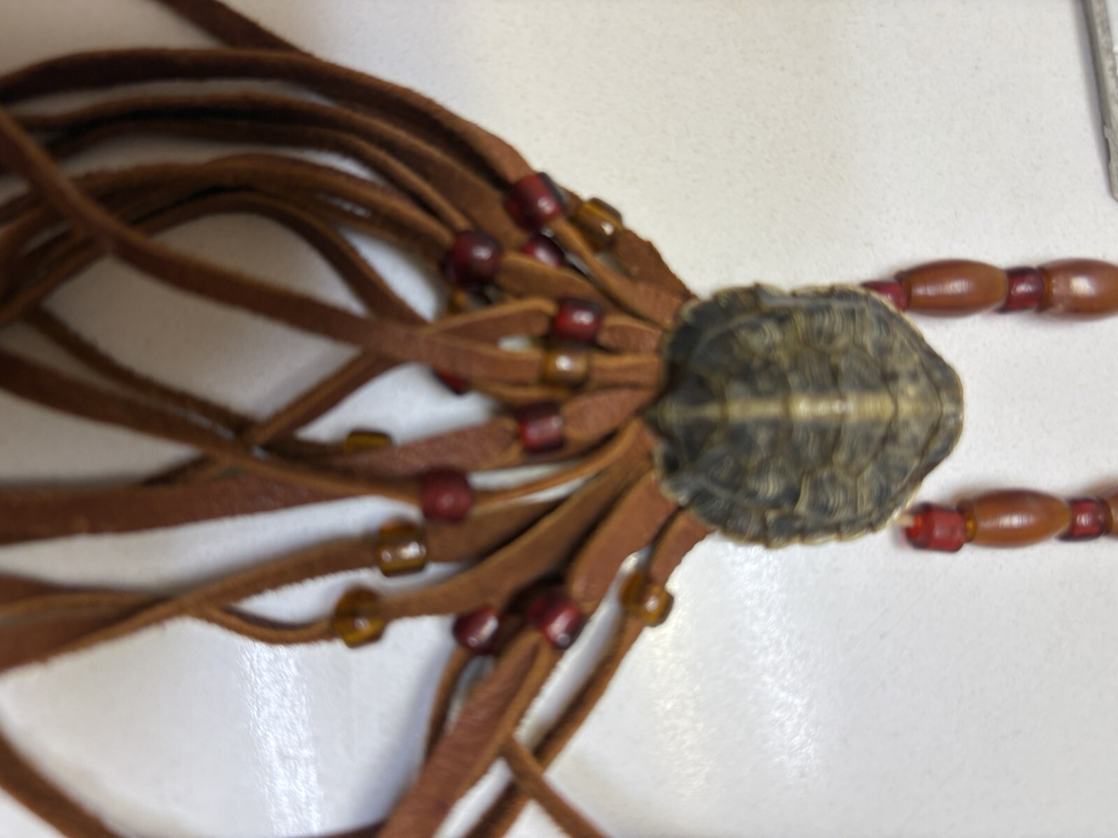 Necklace with turtle motif and rust cording tassel w small orange beads